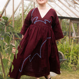 The Double Take Dress in Berry Linen with ribbon appliquè